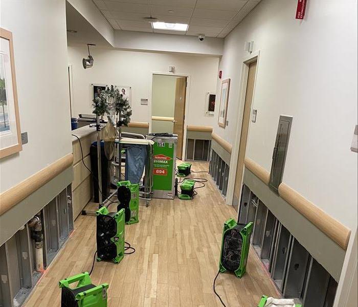 Air movers and dehumidifier in a hallway.
